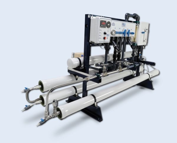 Watermakers | Advanced Reverse Osmosis Desalination Systems - Watermaker WMFQ-7500 reverse osmosis desalination system in a frame configuration. White machine with pipes, dials, buttons and gauges side view.